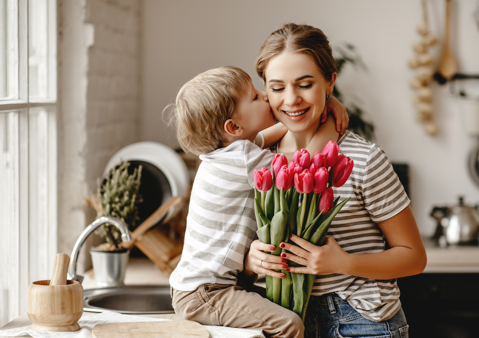 happy mother's day! child son gives flowers for  mother on holiday